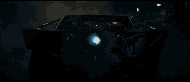 a car is driving down a dark road with smoke coming out of it 's headlights