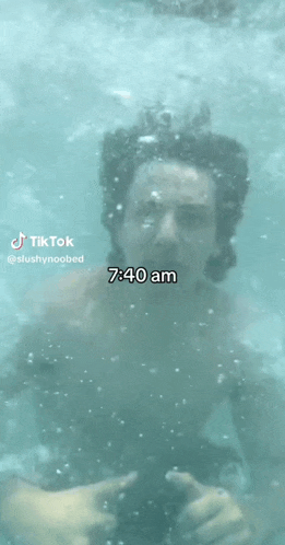 a man is swimming in a pool and the time is 7:40am