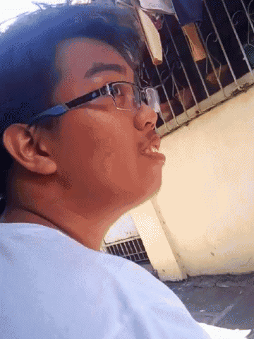 a young man wearing glasses and a white shirt looks to the side