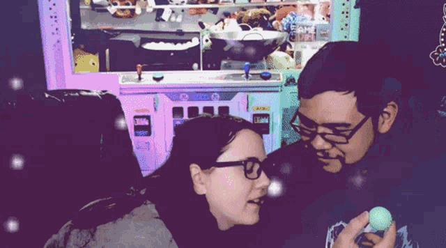 a man and a woman are playing a game in front of a machine that has the word sega on it