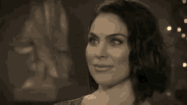 a black and white photo of a woman with a smile on her face