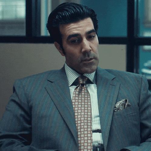 a man in a suit and tie with a checkered pocket square