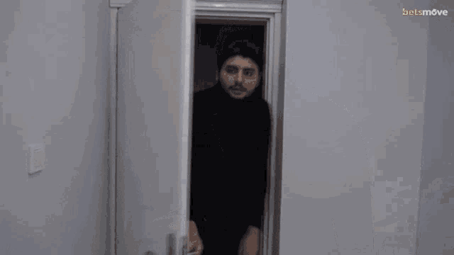 a man in a black shirt is standing in a doorway with the word selmagg above him
