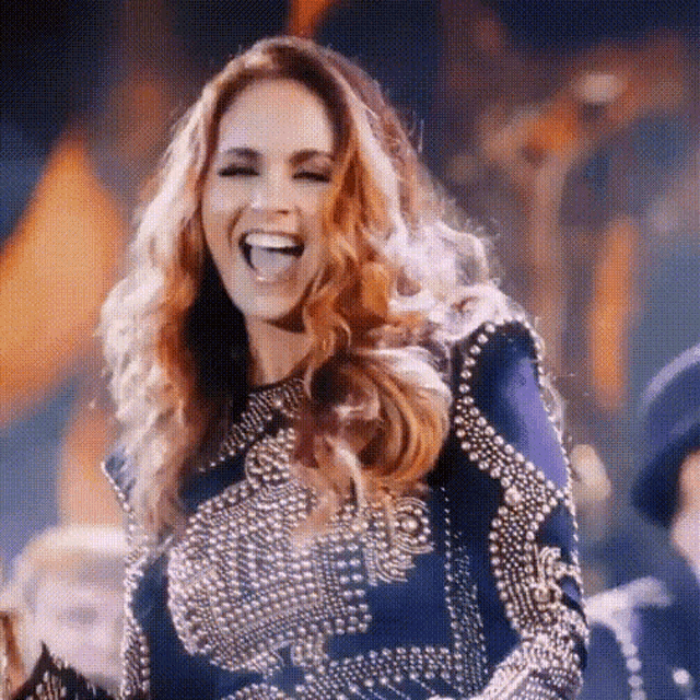 a woman wearing a blue and silver dress is laughing