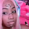 a close up of a woman 's face with pink hair and a tattoo on her face .