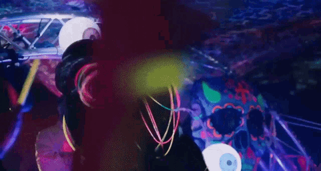 a man in a venom costume is standing in a dark room with neon lights around his neck .