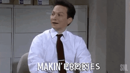 a man in a white shirt and tie is sitting at a desk and saying makin ' proxies
