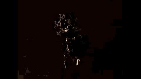 a robot is standing in the dark with a light shining on it 's head .
