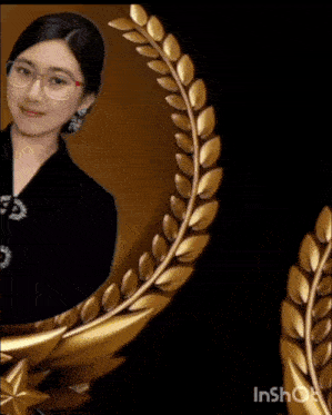 a woman wearing glasses and a black top is in a gold frame