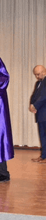a man in a suit is standing next to a woman in a purple dress .