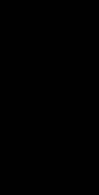 a person is smiling in the dark with sunglasses on .