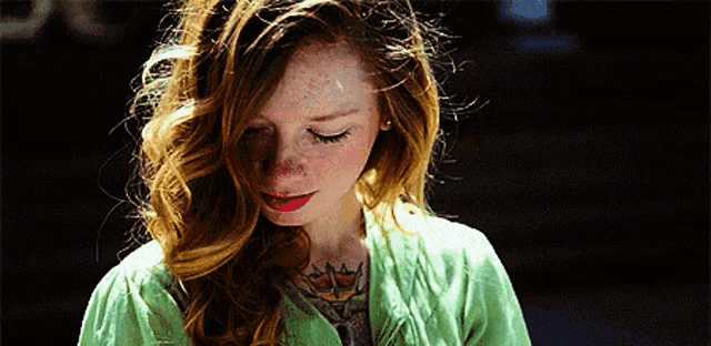 a woman with red hair and a tattoo on her neck