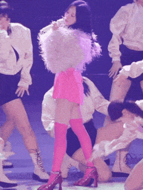 a woman in a pink skirt and thigh high socks is dancing