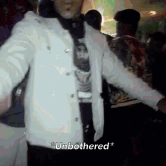 a man in a white jacket is standing in a crowd and says " unbothered " on the bottom