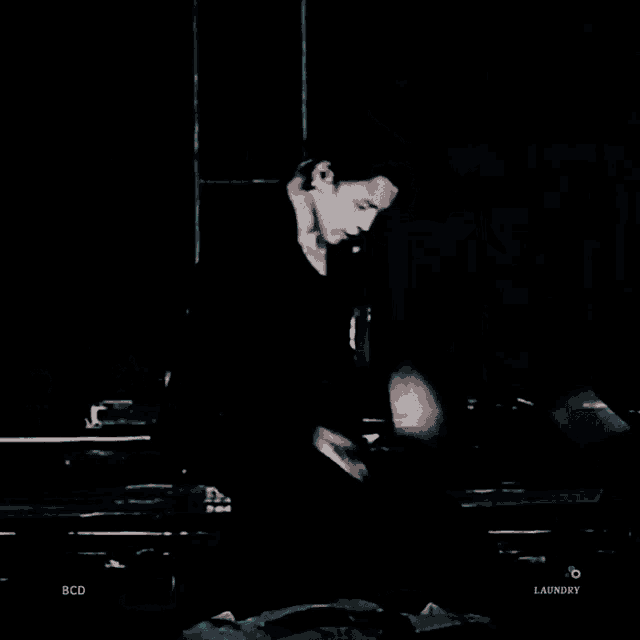 a man is doing a handstand on a stage in a dark room .