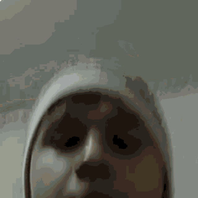 a young boy wearing a hat is looking at the camera .