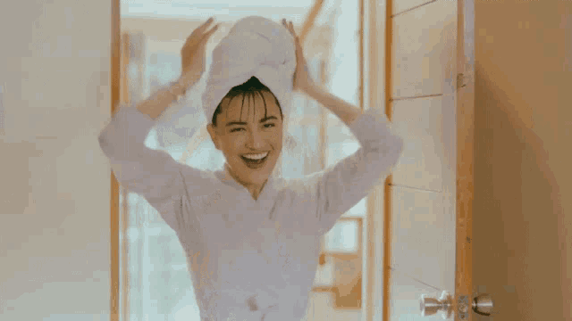a woman with a towel around her head is smiling
