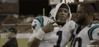 two football players are hugging each other on a field .