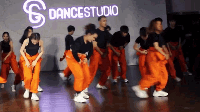 a group of young people are dancing in front of a dancestudio sign