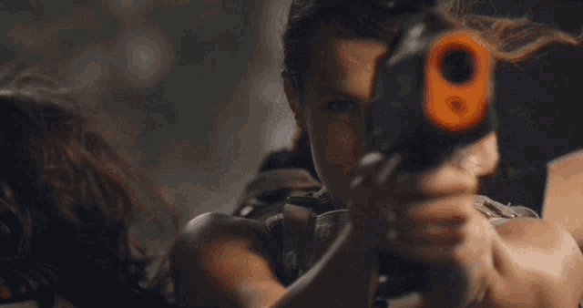a woman holding a toy gun with the number 9 on the front