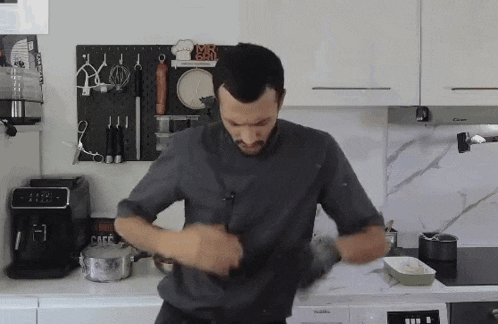a man standing in a kitchen with a sign that says cafe