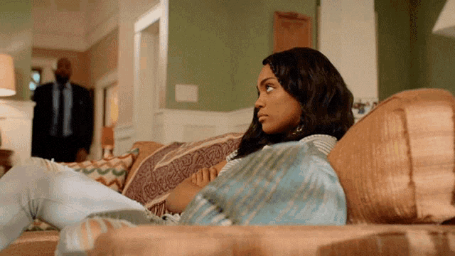 a woman is sitting on a couch looking at something