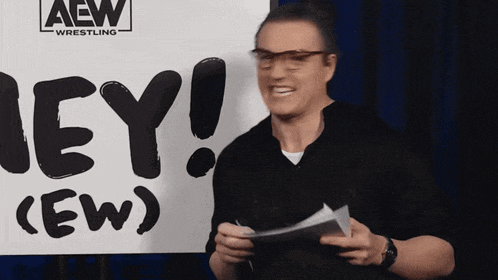 a man holding a piece of paper in front of a sign that says hey