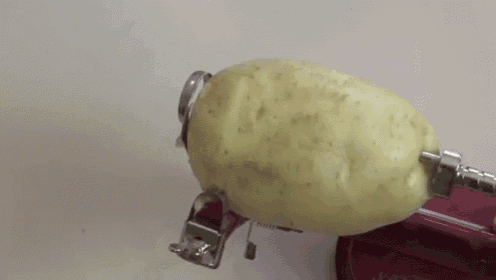 a potato is being peeled by a machine .