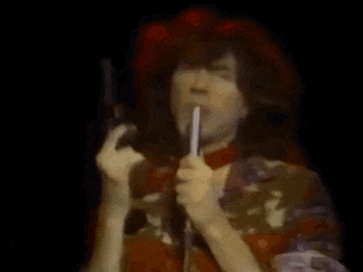a woman in a red hat is holding a microphone in her hand .