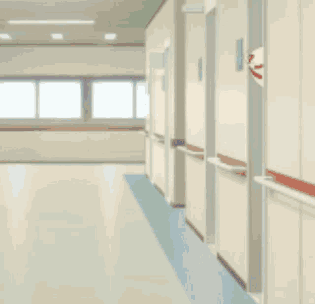 a person in a blue shirt and black shorts is standing in a hospital hallway