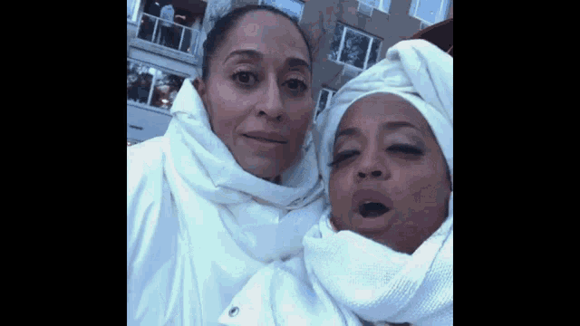 two women wearing white towels on their heads are posing for a picture