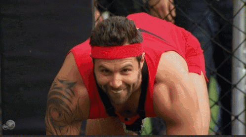 a man wearing a red shirt and a red headband is smiling .