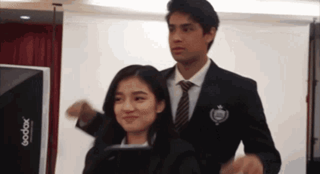 a man in a suit and tie is holding a woman 's hair .