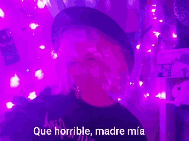 a woman in a black hat is surrounded by purple lights and the words que horrible madre mia