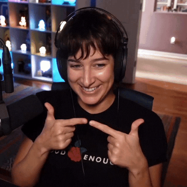 a woman wearing headphones and a t-shirt that says " god enough "