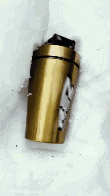 a gold shaker with a sticker on it that says ' sd ' on it