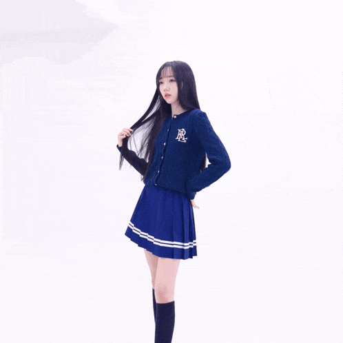 a girl wearing a blue sweater with the letter r on the front