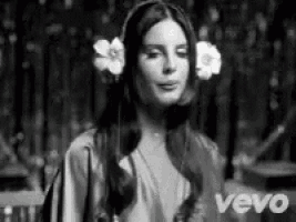 a woman with flowers in her hair is wearing headphones .