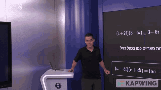 a man stands in front of a blackboard that says kapwing at the bottom