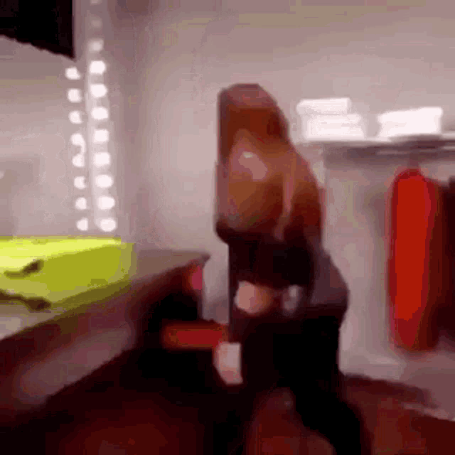 a blurry picture of two people dancing in a room with a yellow suitcase in the background .