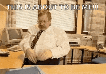 a man in a tie is sitting at a desk in an office .
