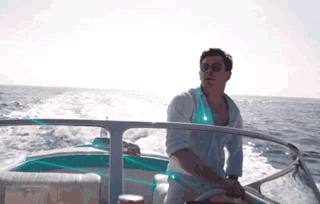 a man wearing sunglasses is driving a boat