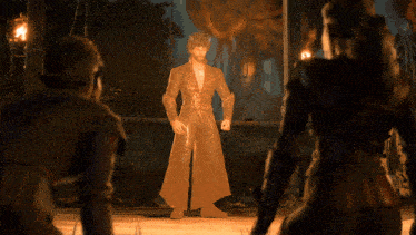 a man in a trench coat is standing in front of two other people