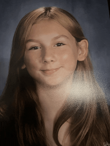 a girl with long red hair is smiling for a picture