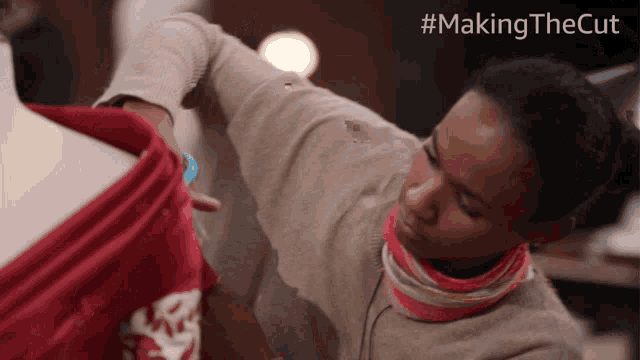a woman is working on a red dress with the hashtag #making the cut