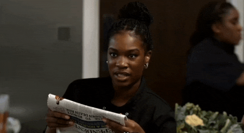 a woman is reading a newspaper that says ' dependent ' on the front page