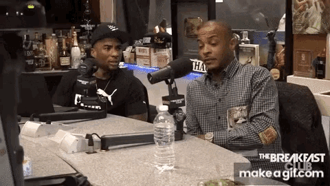 two men are sitting at a table in front of a microphone with the breakfast club make a gif.com on the bottom right