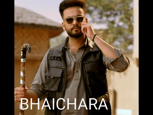 a man wearing sunglasses and a vest is holding a cane and the word bhaichara is on the bottom