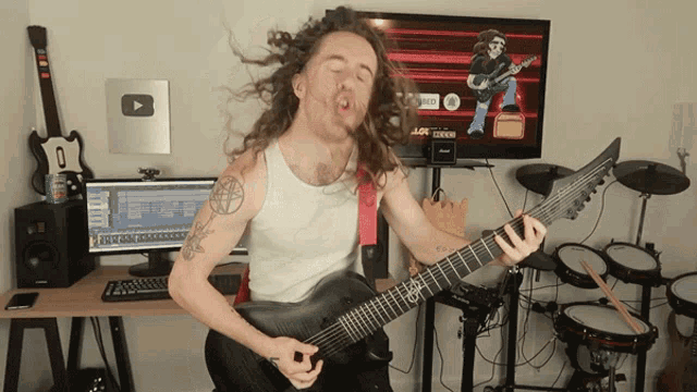 a man playing a guitar in front of a monitor that says ' vox ' on it