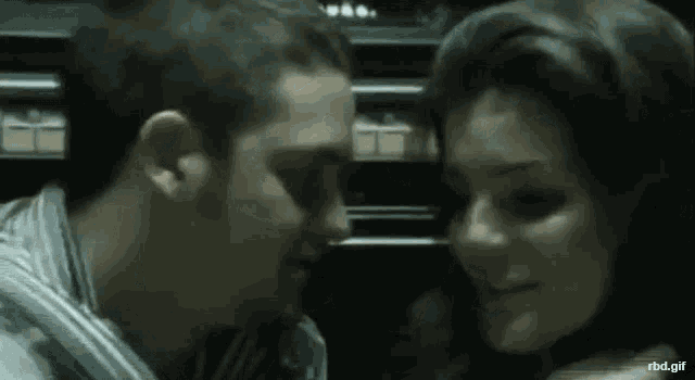 a man and a woman are kissing and hugging in a dark room .